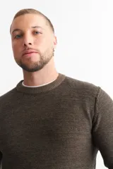 Sweater marrón de punto melange con cuello redondo y mangas largas.