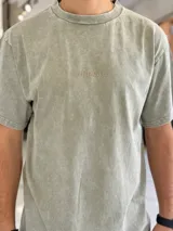 Remera de corte oversize color azul, con efecto gastado y pequeño texto bordado en el pecho.