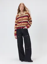 Campera de punto con cierre frontal, diseño de rayas horizontales multicolores y estampado geométrico. Presenta cuello de corderito y puños tejidos.