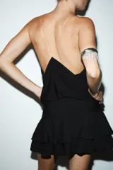 Falda pantalón corta color beige claro, de tiro medio, con efecto drapeado en la cintura y volantes superpuestos en el ruedo.