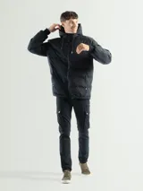Campera puffer negra con capucha integrada y cordones de ajuste. Presenta diseño capitoneado, cierre frontal, bolsillos laterales con cierre y puños elásticos.