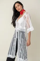 Túnica blanca de tul bordada en hilo, con mangas cortas y terminación de blonda bordada.