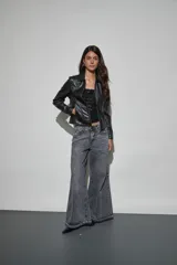 Chaqueta de cuero sintético negro con cierre frontal, cuello clásico y bolsillos laterales.