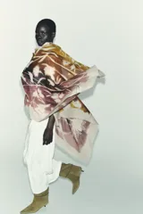 Pañuelo estampado con diseño floral abstracto en tonos marrones, verdes y morados sobre una base beige. Confeccionado en mezcla de tejidos con 9% lana y acabados deshilachados.