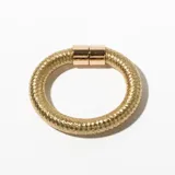 Pulsera rígida dorada con textura acanalada y cierre con piezas cilíndricas.