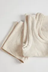 Conjunto de pijama compuesto por una musculosa de escote redondo y un short de tiro alto, ambos confeccionados en tejido suave de textura sutil.