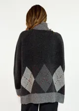 Sweater de cuello alto en color marrón chocolate, con diseño de rombos en la parte inferior en tonos naranja y bordó. Presenta mangas largas con puños acanalados y un corte holgado.