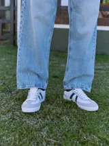 Jean celeste de corte baggy, tiro alto y diseño clásico de cinco bolsillos. Confeccionado en tejido denim con acabado stonewash.