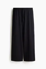 Pantalón negro de punto suave, corte holgado y pierna recta, con cintura elástica y cordón ajustable.