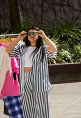 Camisa oversize unisex de lino con spandex a rayas verticales blancas y verdes, con cuello clásico y mangas cortas. Corte amplio y largo a la cadera.