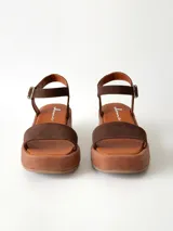 Sandalias de plataforma color chocolate con tira frontal ancha de gamuza y tira al tobillo con hebilla metálica ajustable.