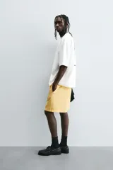 Camiseta de algodón blanca con corte relajado y cuello redondo. Presenta un pequeño bordado en negro con la palabra "BULB" en la parte superior del pecho.