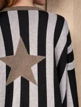 Buzo de punto con diseño de rayas verticales en tonos tostado y beige, con una estrella grande en la espalda y terminaciones en color verde oliva. Presenta un corte holgado y mangas anchas.