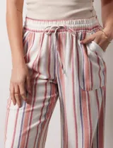 Pantalón de lino de la marca Marissa Olivia, con pretina ancha elastizada y lazo de ajuste. Diseño a rayas verticales en blanco, rojo y azul. Cuenta con bolsillos inclinados en la parte delantera.