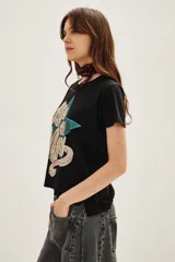 Remera de algodón color negro con estampa frontal gráfica que incluye una estrella verde y la frase Life on Mars en tipografía retro.