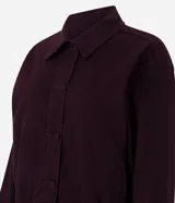 Campera bomber de sarga acanalada en color bordó, con cuello camisero, cierre frontal con botones forrados y puños con ajuste elástico.