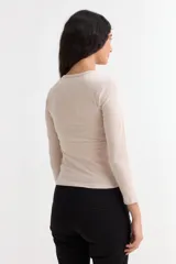 Remera de manga larga con cuello redondo a la base, confeccionada en algodón suave de corte ajustado.