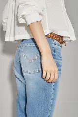 Jean de corte recto y tiro medio, confeccionado en denim de algodón en tono azul lavado. Presenta un diseño clásico con costuras decorativas en los bolsillos traseros y un detalle de bordado sutil en el ruedo.
