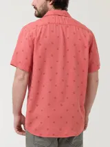 Camisa de manga corta RKF con cuello cubano, confeccionada en Tencel. Presenta un estampado sutil de motivos marinos sobre un fondo color salmón y cierre frontal con botones.