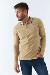 Chomba manga larga color beige con rayas horizontales blancas, cuello polo con borde azul marino y logo bordado en el pecho.