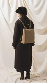 Mochila de diseño moderno y funcional, confeccionada en símil cuero con textura granulada. Cuenta con un bolsillo frontal con broche, cierre principal superior, manija superior y correas ajustables. Incluye logo de la marca grabado en el frente.