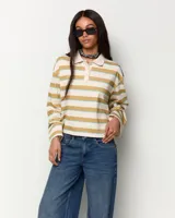 Remera polo de manga larga a rayas horizontales en tonos beige, mostaza y celeste, con cuello camisero y cartera de botones.