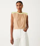 Blusa sin mangas color beige con detalle en los hombros y cuello color verde claro.