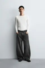 Jeans de denim de algodón, color azul oscuro con efecto lavado. Presentan un corte muy holgado (baggy fit) en toda la pierna y tiro medio. Tienen cinco bolsillos y cierre frontal con cremallera y botón.