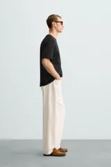 Remera color arena de corte recto, cuello redondo y mangas cortas.