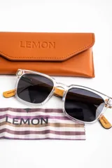 Lentes de sol polarizados con armazón transparente y patillas de madera, con cristales oscuros.