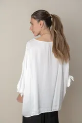 Blusa italiana holgada de color negro liso con detalle de lazos en las mangas. Talle único.