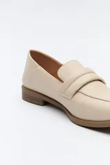 Mocasín negro de cuero sintético con punta cuadrada, detalle de textura en la capellada y taco bajo de 2,5 cm.