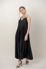 Vestido largo negro de satén plisado, con diseño fluido y tirantes finos.