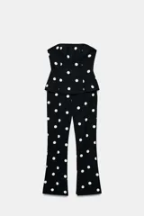 Mono largo de escote recto sin tirantes, con peplum en la cintura, perneras acampanadas y estampado de lunares.