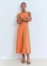 Vestido midi de corte evasé, sin mangas, con cuello caja y cierre posterior de cremallera y botón.
