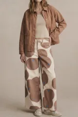 Sobrecamisa de algodón color marrón claro, con cuello camisero y cierre frontal de botones a presión. Presenta detalles de bordado vertical en el frente y en los puños.