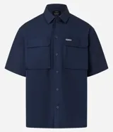 Camisa de manga corta color azul marino de corte boxy, con cuello inglés, cierre frontal de botones metálicos a presión y bolsillos cargo en el pecho.