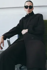 Abrigo oversize de Zara Woman Collection confeccionado en hilatura con lana. Presenta cuello con solapa de muescas, manga larga, bolsillos con solapa en el delantero y cierre frontal cruzado con botones. Incluye forro interior.