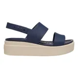Sandalias tipo plataforma Crocs modelo Brooklyn Low Wedge, con tiras superiores en color azul marino y base de plataforma en color beige. Diseño ergonómico con tira ajustable en el talón.
