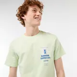 Remera verde claro de manga corta y cuello redondo, con estampa tipográfica en el pecho.