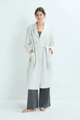 Bata de estar por casa con diseño acolchado, cuello solapa, mangas largas y lazo ajustable en la cintura. Cuenta con bolsillos frontales aplicados.