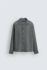 Camisa de corte regular fit confeccionada en tejido fluido con viscosa. Presenta cuello bowling, manga larga con puños abotonados y cierre frontal con botones.