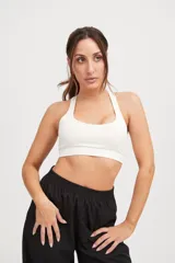 Top deportivo blanco con tiras cruzadas en la espalda y elástico en la cintura.