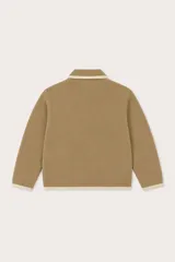 Saco de punto color beige con cierre frontal, cuello tipo polo y detalles de ribete en color crema en el cuello, puños, ruedo y a lo largo del cierre. Cuenta con dos bolsillos laterales tipo ojal.
