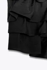 Top bandeau color crema con escote recto, hombros descubiertos y detalle de volantes en capas.