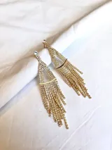 Par de caravanas colgantes doradas con forma triangular y flecos de strass.