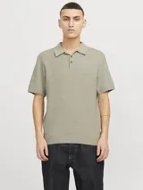 Polo de manga corta confeccionado en tejido de punto estructurado con textura sutil. Presenta cuello clásico, cierre frontal con botones y ajuste regular.