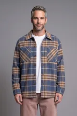 Sobrecamisa a cuadros en tonos azul marino, beige y marrón, con cierre frontal de botones, bolsillos con solapa en el pecho y mangas largas.