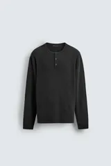 Jersey relaxed fit de algodón color negro, con cuello redondo tipo panadera y cierre frontal de botonadura. Presenta un efecto lavado y manga larga.