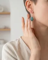 Caravanas de plata 925 con diseño ovalado y piedra turquesa con vetas de cobre.